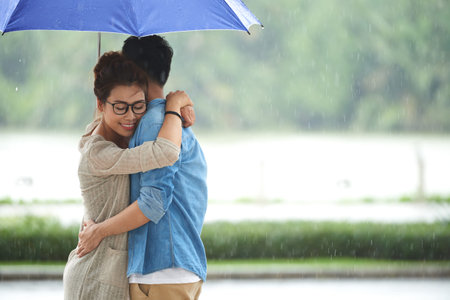 Romantic Young Couple Embracing in Rainの写真素材