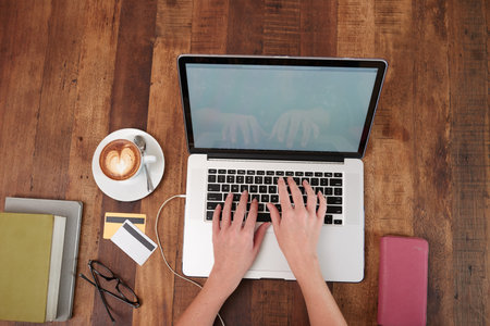 Hands of business lady working on laptop, view form above