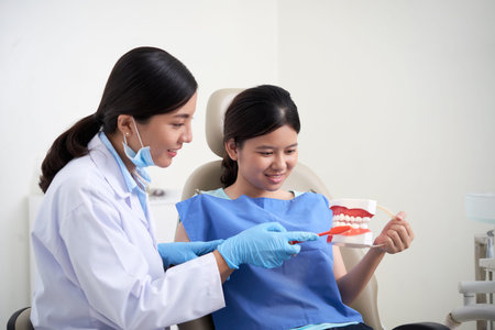 Dentist teaching how to brush teeth