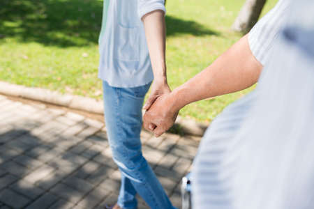 Close-up image of senior man holding hand of his adult daughterの写真素材