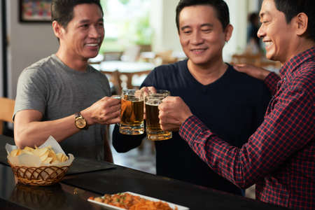 Friends drinking beer in barの写真素材