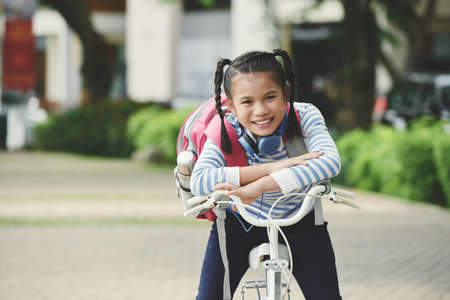 Vietnamese girl with two braids sitting on bicycleの写真素材