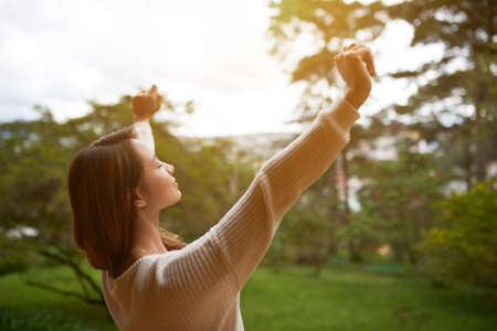 Young Asian woman enjoying warm summer morning in natureの写真素材