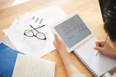 Hands of female it student copying scheme from tablet computer