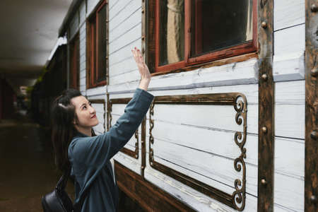 Pretty girl waving to boyfriend in trainの写真素材