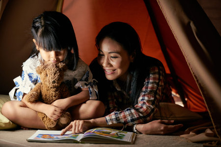 Mother showing picture from the book to her daughter