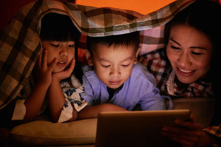 Family watching cartoons at nightの写真素材