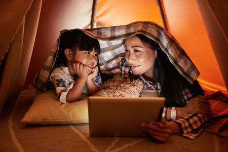 mother and daughter watching tv shows onlineの写真素材