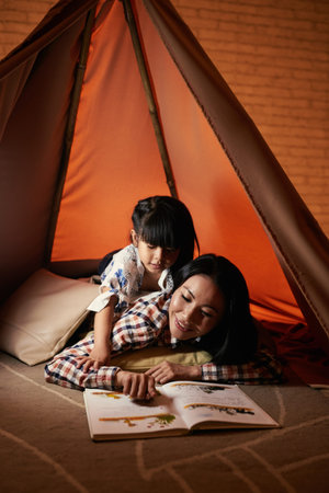 Mother and daughter  Reading book together