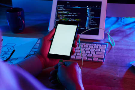 Programmer testing new app on smartphoneの写真素材