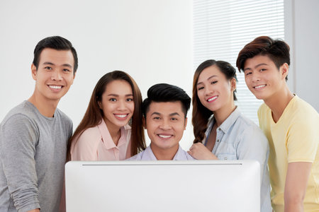 Group of young team looking at computer