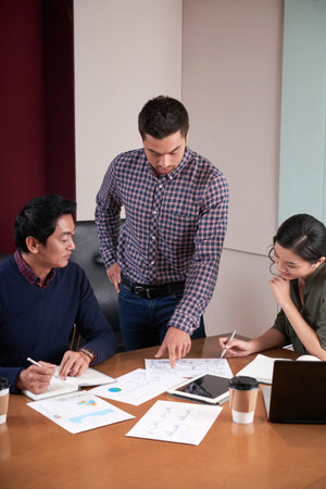 Businessman showing report he made to coworkers