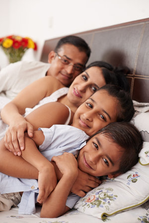 cheerful loving family on the bed