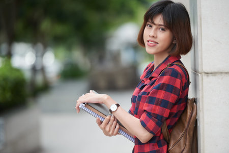 Pretty student carrying book to classの写真素材