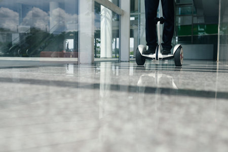 Person on gyroscooter riding along office corridorの写真素材