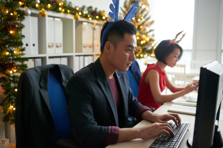 Business people working in office decorated with Christmasの写真素材