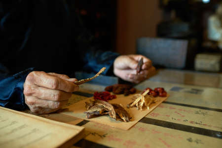 Young man packing remedy ingredientsの写真素材