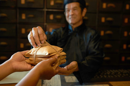 Traditional Chinese medicine practitioner giving packs with herbs to the customer