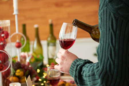 Pouring red wine in glassの写真素材
