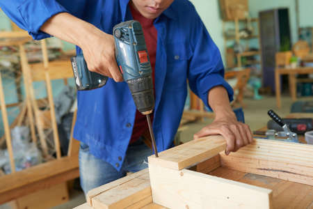 Professional carpenter connecting wooden planks with screwsの写真素材