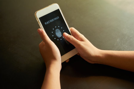 Hands of person touching smartphone screen for idefication