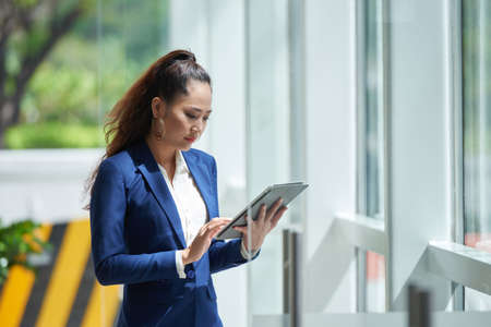 Vietnamese business lady checking document on digital tabletの写真素材