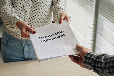 Assistant giving partnership agreement to the bossの写真素材
