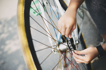 Close-up image of woman fixing bicycle chain