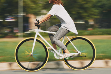 Cropped image of cycling young woman, blurred motionの写真素材