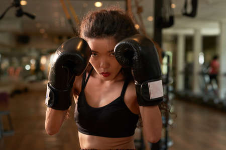 Portrait of Asian female fighter in boxing glovesの写真素材