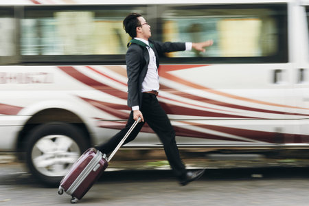 Businessman with suitcase running to catch the bus
