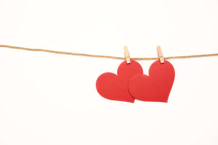 Close-up shot of two red Valentines cards hanging on twine, isolated on white backgroundの写真素材