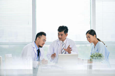 Asian doctors discussing innovations in medicine at the meetingの写真素材