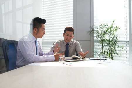 Vietnamese coworkers discussing strategy for business developmentの写真素材