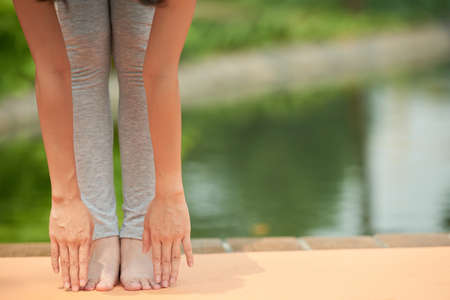 Cropped image of woman bending forward to stretch her legsの写真素材