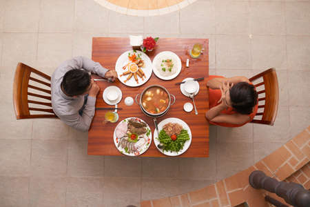 Directly above view of loving young couple celebrating momentous event in luxurious restaurant while having romantic dateの写真素材