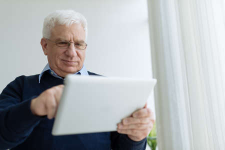 Aged man with digital tabletの写真素材