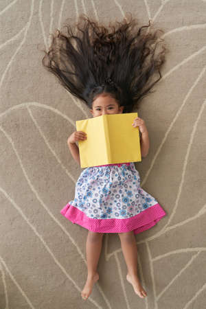 Cheerful girl with bookの写真素材