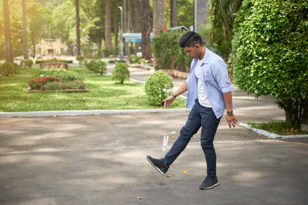 Young Asian man playing traditional game shuttlecock kicking in parkの写真素材