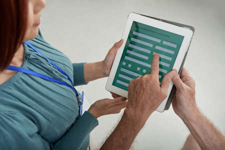 Inrance agent helping man to fill the online formの写真素材