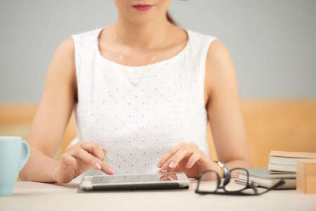 Cropped image of female business executive working on digital tabletの写真素材