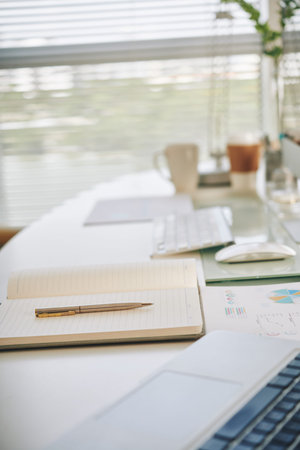 Empty opened notepad and pen on table