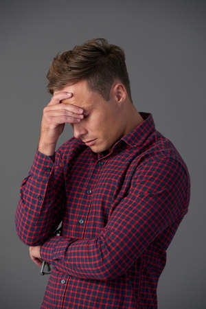 Sad man suffering from headache or emotional stressの写真素材