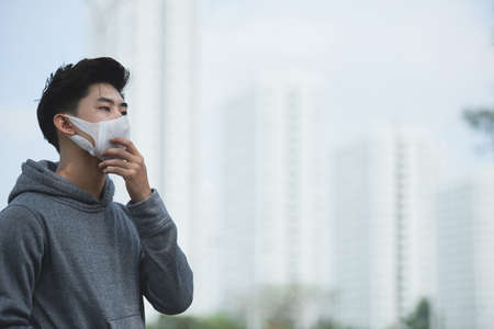 Vietnamese young man in polluted city covered with heavy smogの写真素材