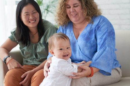 Happy little mixed-raced boy with his two mothers