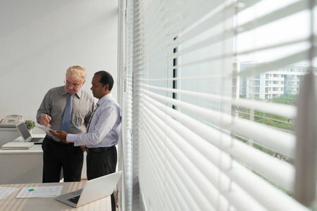 Multi-ethnic business people dicussing financial report in office