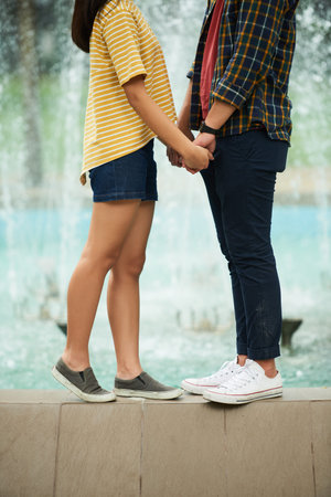 Cropped image of young couple holding hands and looking at each other