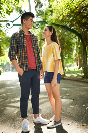 Smiling young Vietnamese woman looking at her boyfriend