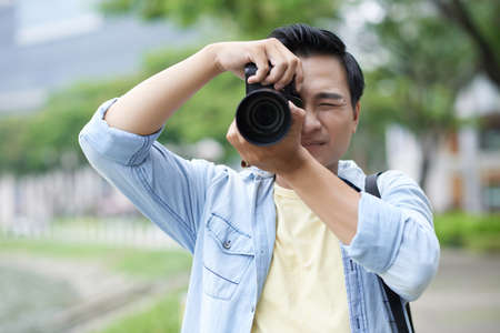 Vietnamese man photographing with professional dslr cameraの写真素材