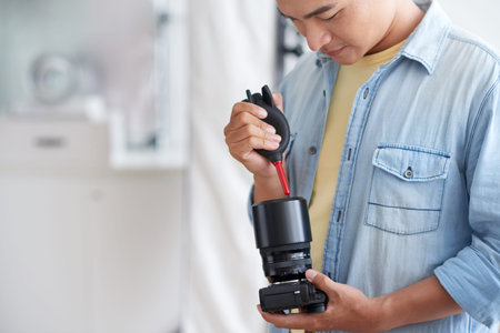 Professional photographer cleaning lens with special kit